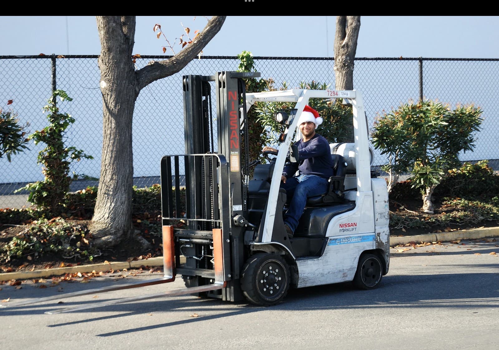 Andrey Dini moving freight on a forklift, wearing a Santa hat, during the December drive