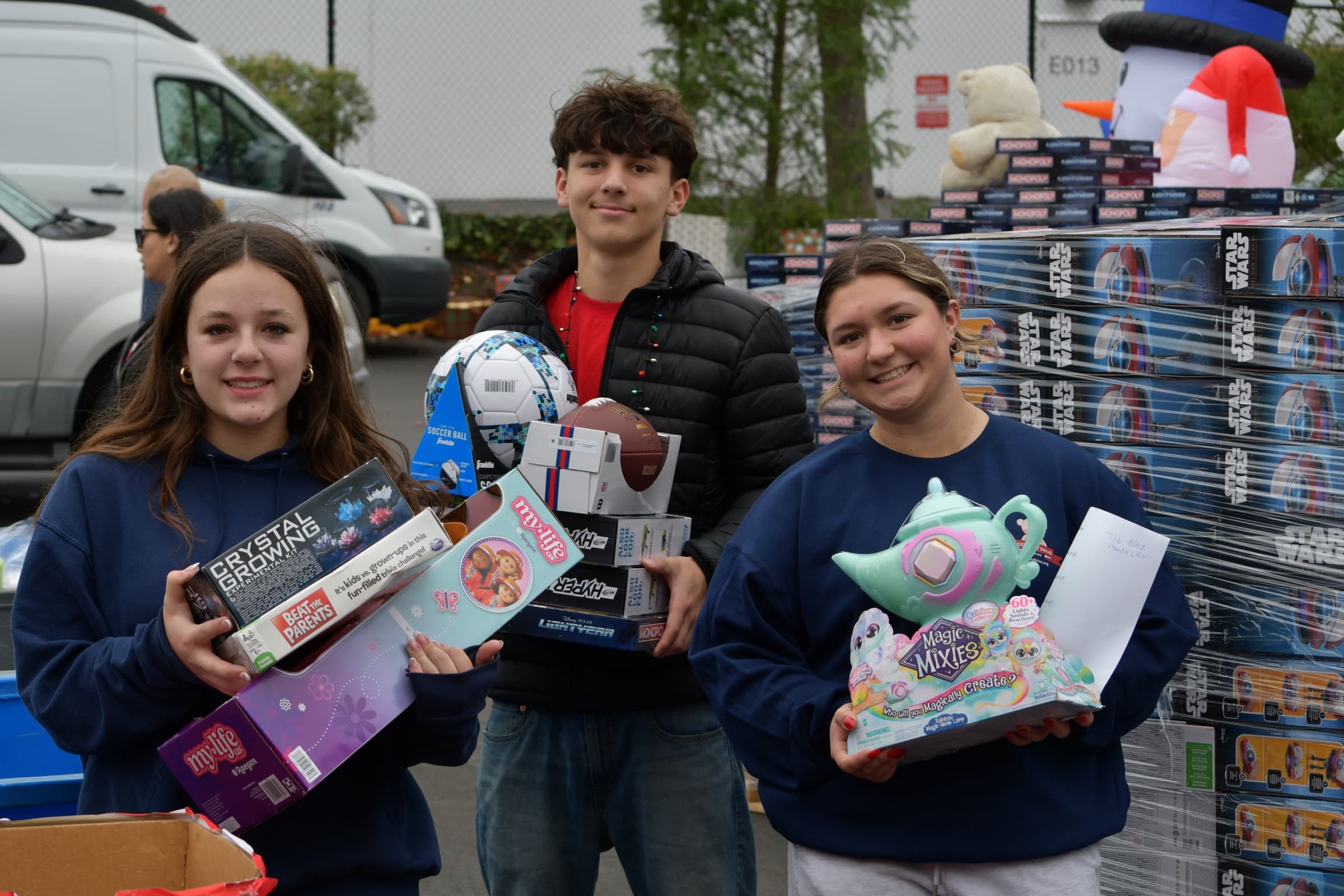 Three volunteers holding gifts at Joey's Toy Drive